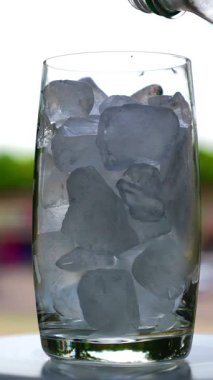 Bir bardak buzlu su, yakın çekim, damlacıklar ve kabarcıklar, taze yaz serinliği, ferahlatıcı bir hava.