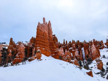 Snow scene colorful cliffs with  red rock and stone in Bryce Canyon National Park clipart