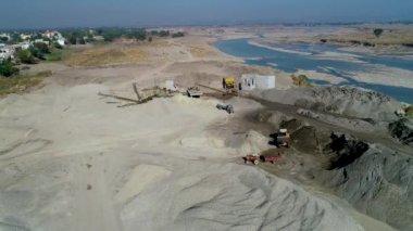 Kazıcının ezilmiş taş makinesini yüklediği görüntü. Üst Hava Görünümü
