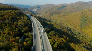 Dar vadi yolları boyunca kıvrılan, yemyeşil ve yuvarlanan tepelerle çevrili, dinamik bir 4K hava manzarası. Virajlı yollar resmedilmeye değer doğal manzarayla uyum içinde..