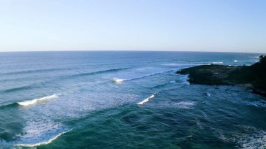 Sahil şeridinin yukarısında, el değmemiş bir plajın çarpıcı hava manzarasıyla süzül. Kristal berraklığında sular, yumuşak, altın gibi kumlarla buluşur ve mavi ile beyazın mükemmel bir karışımını yaratır. Ritmik dalgalardan sakin kıyılara büyüleyici bir manzara..