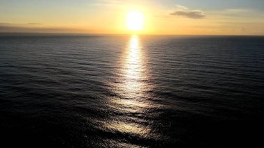 Güneşin doğuşunun nefes kesen güzelliğini deneyimleyin, ışığın ilk ışınları ufku aydınlatır ve gökyüzünü turuncu, pembe ve altın renkli canlı renklerle boyar. Doğanın günlük şaheserine tanık olun. Dünya uyanıyor, barış anı sunuyor..