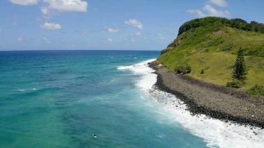 Sahil şeridinin yukarısında, el değmemiş bir plajın çarpıcı hava manzarasıyla süzül. Kristal berraklığında sular, yumuşak, altın gibi kumlarla buluşur ve mavi ile beyazın mükemmel bir karışımını yaratır. Ritmik dalgalardan sakin kıyılara büyüleyici bir manzara..