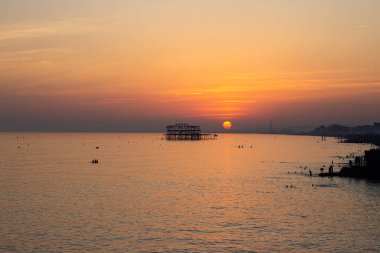 Günbatımı Brighton plajında, arkasında güneş varken.