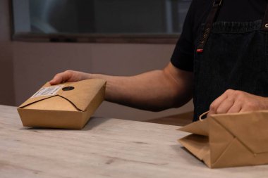 Tezgahtar çantaya bir kutu koydu.