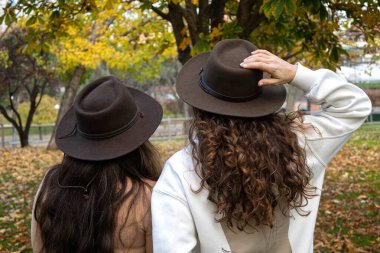 Sırtında şapkası olan iki kadın.