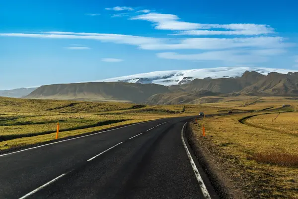 stock image A winding road stretches towards towering mountains and glaciers