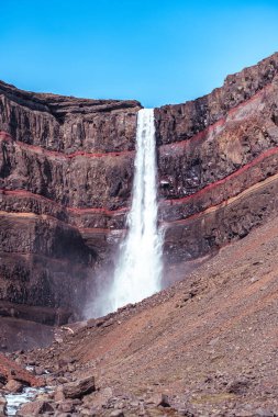 Doğu İzlanda 'daki Hengifoss şelalesine giden yolun çarpıcı manzarası, engebeli kayalıklar ve bazalt sütunlarla çevrili. Şelale gibi akan su sakin bir vadiye akıyor, nefes kesici manzaralar sunuyor ve Ic 'i keşfeden yürüyüşçülere ödüllendirici bir deneyim sunuyor.