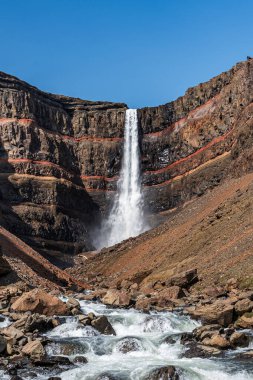 Doğu İzlanda 'daki Hengifoss şelalesine giden yolun çarpıcı manzarası, engebeli kayalıklar ve bazalt sütunlarla çevrili. Şelale gibi akan su sakin bir vadiye akıyor, nefes kesici manzaralar sunuyor ve Ic 'i keşfeden yürüyüşçülere ödüllendirici bir deneyim sunuyor.