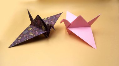 Batik dokulu ve pembe kuş origamisine sahip Origami şekilli kuş.