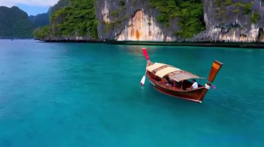 Denizde tekneleri olan güzel bir tropikal ada. Uzun kuyruk teknesi tropikal bölgede yol alıyor.