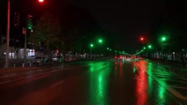 Islak sokak yeşil ışıkla aydınlatılmış. Ulaşım ve şehir konsepti tasarımları için uygundur