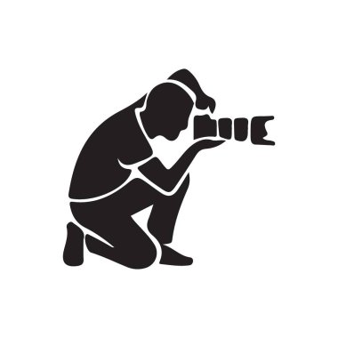 Diz çökmüş bir fotoğrafçının siluet çizimi profesyonel bir kamera kullanarak alçak açılı bir fotoğraf çekiyor. Fotoğraf konseptleri ve ekipmanlar için ideal.