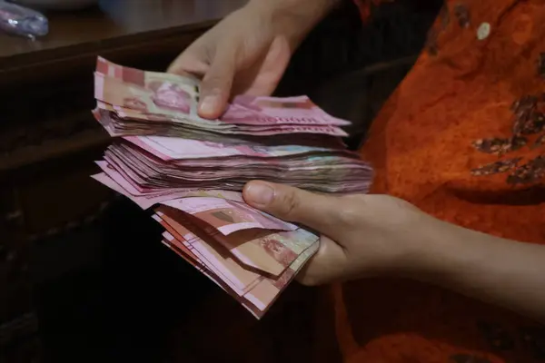 Endonezya Rupiah parasını elinde tutan kadın.