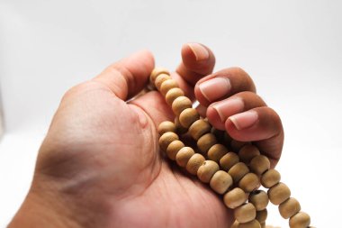 Asyalı bir erkek, elinde tespih, tespih, arkaplan ve tespih taşır..