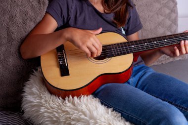 Genç kız yatak odasında gitar çalmayı öğreniyor..