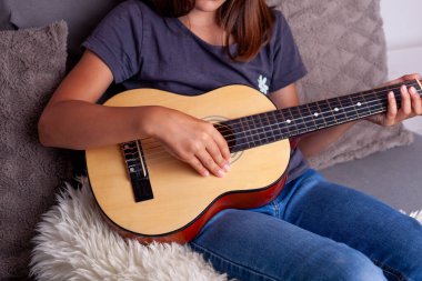 Genç kız yatak odasında gitar çalmayı öğreniyor..