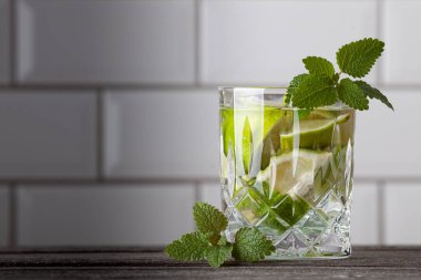 Resmin sağ tarafında duran orijinal Caipirinha kokteyli. Metin için boş alan. Nane, rom, limon, şeker ve buzlu lezzetli bir kokteyl..