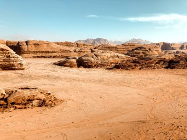 Kayalar, gölgeler, kırmızı ve turuncu kumlar ve yürüyüş yollarıyla eşsiz bir çöl manzarası.