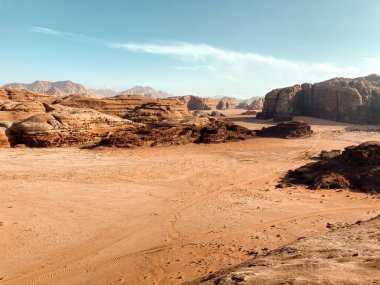 Kayalar, gölgeler, kırmızı ve turuncu kumlar ve yürüyüş yollarıyla eşsiz bir çöl manzarası.