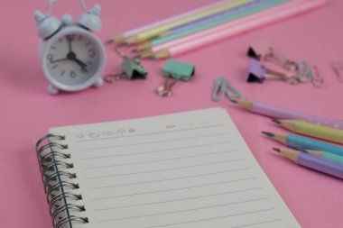 Pembe ofis aletleri, pembe kulaklık, not defteri, kalem ve pembe arka planda bir buket pembe lale fotokopi alanı konsepti.