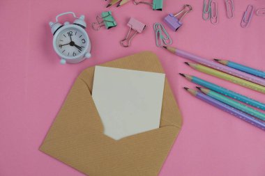 Pembe ofis aletleri, pembe kulaklık, not defteri, kalem ve pembe arka planda bir buket pembe lale fotokopi alanı konsepti.