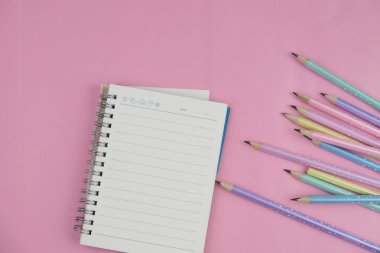 Pembe ofis aletleri, pembe kulaklık, not defteri, kalem ve pembe arka planda bir buket pembe lale fotokopi alanı konsepti.