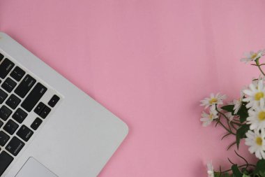 Pembe ofis aletleri, pembe kulaklık, not defteri, kalem ve pembe arka planda bir buket pembe lale fotokopi alanı konsepti.