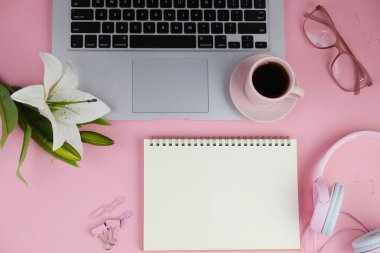 Pembe ofis aletleri, pembe kulaklık, not defteri, kalem ve pembe arka planda bir buket pembe lale fotokopi alanı konsepti.