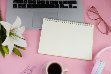 Pembe ofis aletleri, pembe kulaklık, not defteri, kalem ve pembe arka planda bir buket pembe lale fotokopi alanı konsepti.