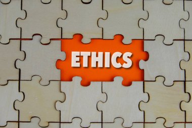 Ethics words on the missing part of wooden puzzle with letters, ethics moral philosophy concept, business and management concept. Orange background.  clipart