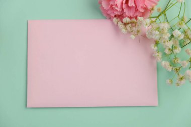 Üzerinde pembe gül tomurcukları olan üst görüntü, gypthe, huzurlu bir pastel arka planda mesaj, aşk ve romantik konsept için metin alanı ile birlikte.