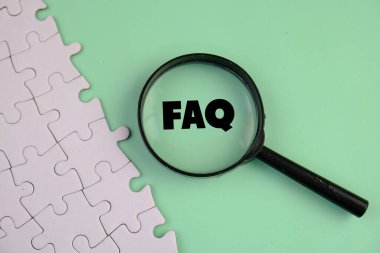 Pembe sade arka planda yönetim ve iş konsepti üzerine büyüteç altında sıklıkla sorulan soru kısaltması.. 
