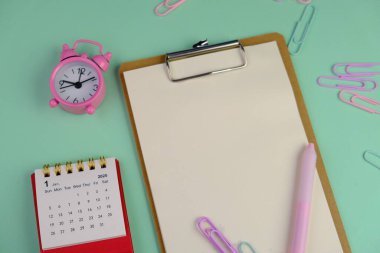 Metin alanı için boş bir not defterinin düz uzantısı. Pembe arka planda metin alanı olan eğitici bir kavram. kalem, alarm saati ve hesap makinesi gibi sarı araçlarla çevrelenmiş