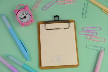 Metin alanı için boş bir not defterinin düz uzantısı. Pembe arka planda metin alanı olan eğitici bir kavram. kalem, alarm saati ve hesap makinesi gibi sarı araçlarla çevrelenmiş