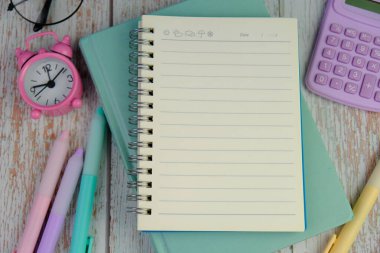 Metin alanı için boş bir not defterinin düz uzantısı. Pembe arka planda metin alanı olan eğitici bir kavram. kalem, alarm saati ve hesap makinesi gibi sarı araçlarla çevrelenmiş