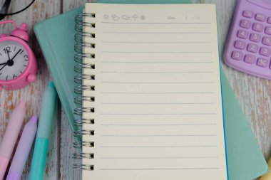 Metin alanı için boş bir not defterinin düz uzantısı. Pembe arka planda metin alanı olan eğitici bir kavram. kalem, alarm saati ve hesap makinesi gibi sarı araçlarla çevrelenmiş