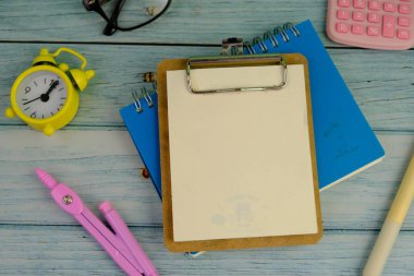 Metin alanı için boş bir not defterinin düz uzantısı. Pembe arka planda metin alanı olan eğitici bir kavram. kalem, alarm saati ve hesap makinesi gibi sarı araçlarla çevrelenmiş