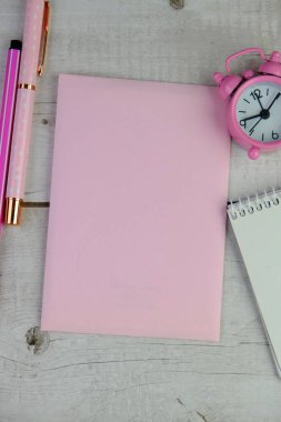 Ev ofisinin bilgisayar, pano, palmiye yaprağı, defter ve aksesuarlı çalışma alanı modeli. Düz yerde, üst tarafta. Pembe tema