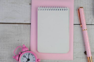 Ev ofisinin bilgisayar, pano, palmiye yaprağı, defter ve aksesuarlı çalışma alanı modeli. Düz yerde, üst tarafta. Pembe tema