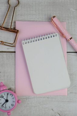 Ev ofisinin bilgisayar, pano, palmiye yaprağı, defter ve aksesuarlı çalışma alanı modeli. Düz yerde, üst tarafta. Pembe tema