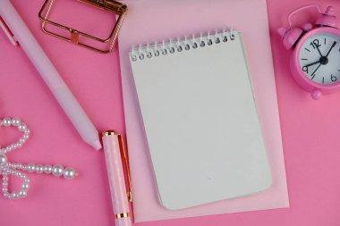 Ev ofisinin bilgisayar, pano, palmiye yaprağı, defter ve aksesuarlı çalışma alanı modeli. Düz yerde, üst tarafta. Pembe tema