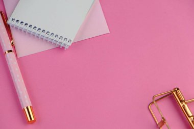 Ev ofisinin bilgisayar, pano, palmiye yaprağı, defter ve aksesuarlı çalışma alanı modeli. Düz yerde, üst tarafta. Pembe tema