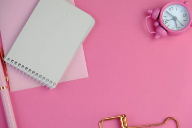 Ev ofisinin bilgisayar, pano, palmiye yaprağı, defter ve aksesuarlı çalışma alanı modeli. Düz yerde, üst tarafta. Pembe tema