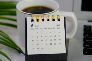 Eylül 2025 için bir ofis arka planında aylık masa takvimi. 