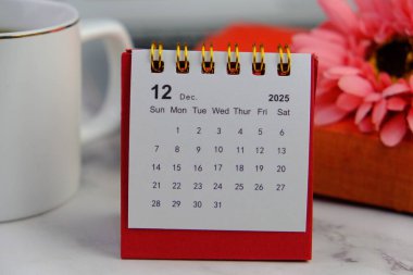 Aralık 2025 tarihli aylık masa takvimi ofis arka planında. 