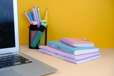 Canlı sarı bir arka planda okul malzemeleri çeşitliliğinin en üst görüntüsü. bu resim renkli kalemler, defterler, makas, silgi ve ataçlar içerir, metin alanı ile okula dönüş kavramı