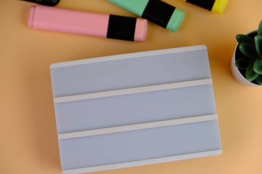 Canlı sarı bir arka planda okul malzemeleri çeşitliliğinin en üst görüntüsü. bu resim renkli kalemler, defterler, makas, silgi ve ataçlar içerir, metin alanı ile okula dönüş kavramı