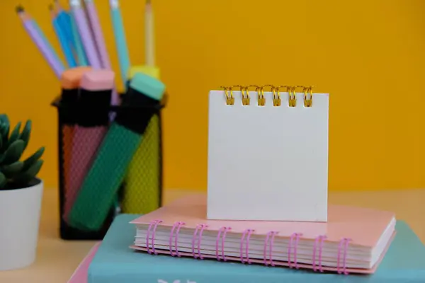 Canlı sarı bir arka planda okul malzemeleri çeşitliliğinin en üst görüntüsü. bu resim renkli kalemler, defterler, makas, silgi ve ataçlar içerir, metin alanı ile okula dönüş kavramı