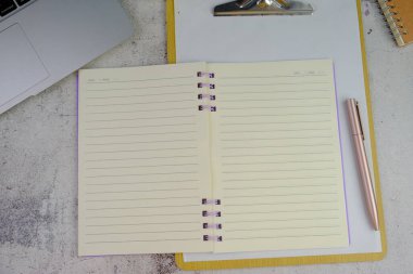 Boş beyaz kağıt, bilgisayar klavyesi, gözlük ve kalemle gri masanın üstünde düz bir tabela. Kontrol Listesi